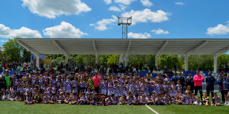 La ‘Fuente de la Niña’ se tiñe de morado y blanco para celebrar el Día del Club del Atlético Guadalajara El pasado fin de semana, la Fuente de la Niña de Guadalajara se convirtió en el escenario perfecto para conmemorar el Día del Club del Atlético Guadalajara. Una jornada repleta de emoción, fútbol y convivencia, en la que cerca de un millar de personas se dieron cita para celebrar el décimo aniversario del club y el cierre de la temporada 2024-2025. Una jornada llena de actividades para toda la familia arlequinada Desde primera hora de la mañana, los campos de la Fuente de la Niña se vieron inundados de los colores representativos del club: blanco y morado. Niños, jóvenes y adultos se reunieron para disfrutar de una jornada cargada de actividades deportivas. El evento comenzó con los torneos de las categorías benjamín y benjamín femenino, y siguió con una serie de encuentros entre los equipos de distintas categorías del club. En total, cerca de 500 jugadores participaron en este evento, que no solo incluyó a los miembros del Atlético Guadalajara, sino también a equipos invitados como el Deportivo Guadalajara, Galápagos, Dínamo Guadalajara, Salesianos, Spórting Cabanillas, Horche y Valdeluz. La cantera arlequinada en pleno auge El Atlético Guadalajara ha experimentado un notable crecimiento en los últimos años. Su cantera, compuesta por 21 equipos (masculinos y femeninos), alberga a más de 300 jugadores que se sumaron a esta gran celebración deportiva. Este incremento en la participación es un reflejo del éxito y la popularidad del club en la región. La fiesta no solo se vivió dentro de los campos, sino también en el ambiente que se generó alrededor: música, sorteos y diversión para todos los asistentes crearon una atmósfera única. Al final del día, todos los jugadores de la cantera arlequinada se reunieron en un tradicional desfile, que culminó con una emotiva foto de familia. Homenajes a los jugadores con más trayectoria El Día del Club también fue la ocasión perfecta para rendir homenaje a los jugadores más comprometidos con la camiseta del Atlético Guadalajara. En esta edición, se reconoció a los jugadores que cumplen cinco y diez años defendiendo la elástica arlequinada, los conocidos como los ‘One Club Man’. Jugadores con cinco años de trayectoria: Mateo García Javier Martínez Jack Dylan Alfonso Monge Ángel Gómez (Pitu) Jugadores con diez años de trayectoria: Jaime Serra (Peke) Diego Alba Estos jugadores fueron obsequiados con un pequeño detalle como muestra de agradecimiento por su dedicación y fidelidad al club. Gran victoria en el último partido de la temporada La jornada concluyó con un emocionante partido del equipo senior del Atlético Guadalajara contra el Almoguera en el marco de los playoffs de ascenso a Primera Autonómica. Los atléticos lograron una importante victoria, que les permitió meterse de lleno en la lucha por el ascenso, añadiendo un toque de emoción al cierre de la temporada. Mirando al futuro: planificación para la próxima temporada El Atlético Guadalajara ya se encuentra trabajando en la planificación de la próxima temporada. Como es habitual, el club dará inicio a sus actividades con el Campus de Verano, que en 2025 celebrará su décima edición. Este campus comenzará el 23 de junio y se extenderá hasta el 25 de julio. Las inscripciones estarán abiertas en breve, brindando una excelente oportunidad para que los jóvenes de la región se acerquen al mundo del fútbol. Además, el club ha programado varias jornadas de puertas abiertas para las categorías juvenil y senior femenino durante este mes de mayo. También se llevarán a cabo jornadas similares para otras categorías en el mes de junio, permitiendo que todos aquellos interesados puedan conocer las dinámicas de entrenamiento y formar parte de la familia arlequinada en la temporada 2025-2026. Conclusión El Día del Club del Atlético Guadalajara fue un evento memorable que celebró no solo la temporada 2024-2025, sino también el décimo aniversario de un club que sigue creciendo y consolidándose en la región. Con una cantera en auge, un ambiente lleno de energía y una gran victoria en el último partido, el futuro del Atlético Guadalajara promete grandes momentos para su afición. ¡No te pierdas las próximas actividades y únete a la familia arlequinada!